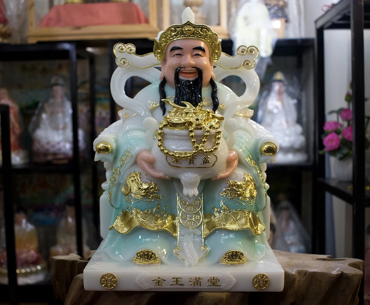 Tượng Ông Thần Tiền bằng bột đá ngồi ghế, áo xanh